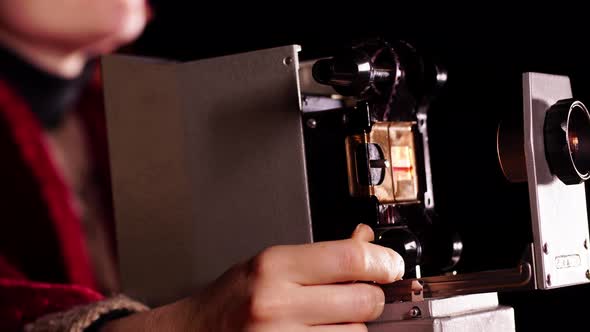 Closeup of an Old Slide Projector and Hand Spinning a Wheel That Moves the Film with Pictures