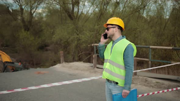 Portrait of an Engineer to Make Call for Business Discussion Holding Document