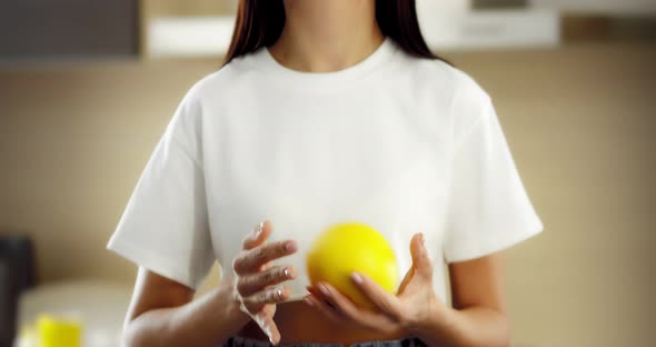 Asian Woman with a Beautiful Smile Holds a Citrus Fruit