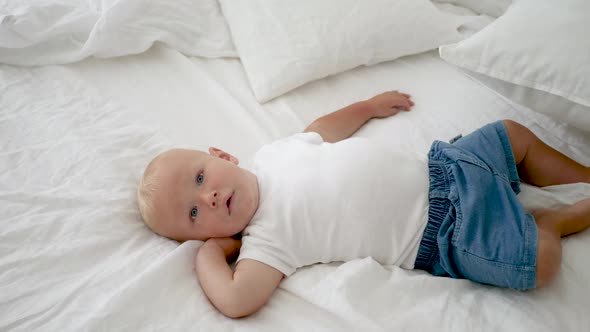 Boy with Blue Eyes in a White T-shirt and Blue Shorts