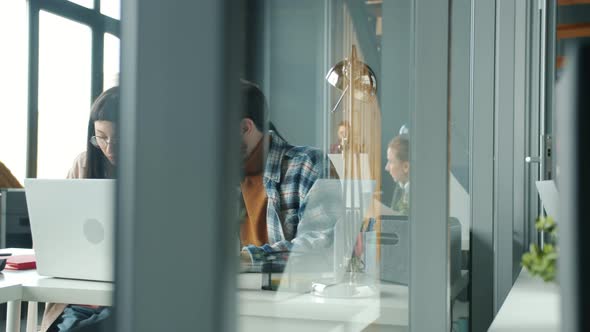 Confident Manager Explaining Corporate Software to New Employee Working with Laptop Together