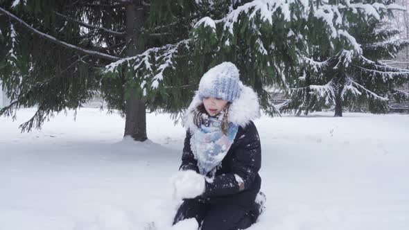 Teenage Girl Tosses Fresh Snow While Playing in Park