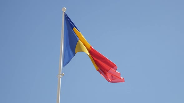 National flag of Romania waving against blue sky 4K 2160p 30fps UltraHD footage - Romanian state sym
