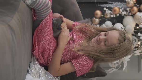 Smiling Little Girl Stroking Kitten in Xmas