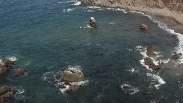 Birds sitting on Arched Rock on the ocean with waves crashing near the Beach Bodega Bay Highway 1 in