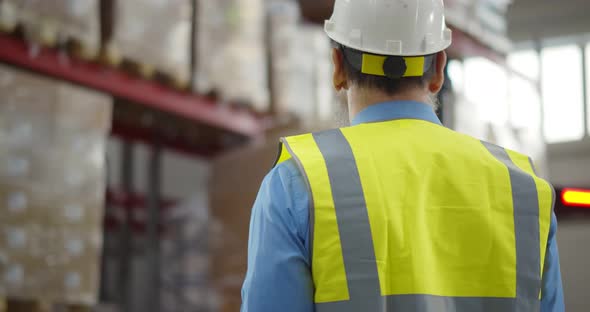 Senior Warehouse Manager Using Walkietalkie at Workplace