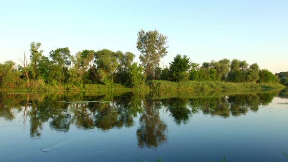 Scenery of Silent Rural Lake Near Green Forest.