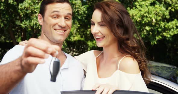 Couple interacting with each other near car