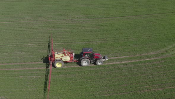 Tractor Sprays Fertilizers over Crop Field