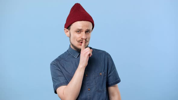 Portrait of Bearded Guy Wearing Modern Clothing Posing with Strict Gaze and Asking Not to Disturb