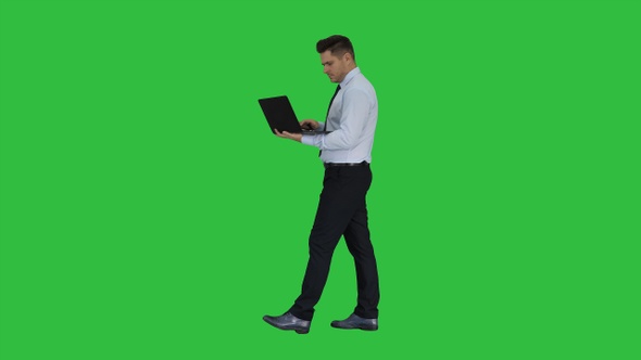 Formal man walking and using laptop on a Green Screen, Chroma Key.