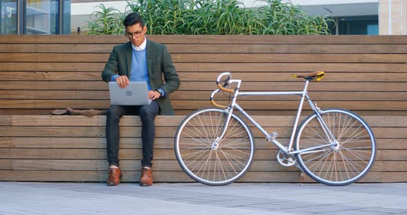 Businessman using laptop on street 4k