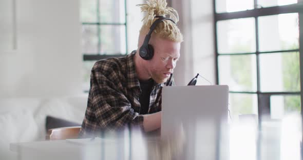 Happy albino african american man with dreadlocks making podcast