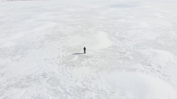 Cinematic View Of Person Standing On Frozen Lake