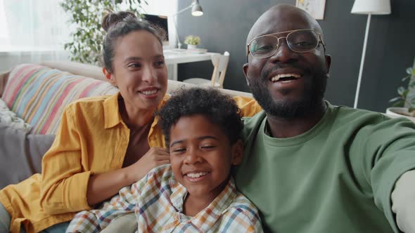 Positive Afro Family Chatting on Video Call at Home