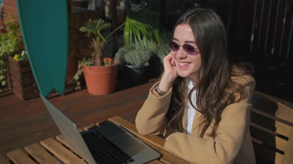 Smiling Girl in Stylish Clothes with a Laptop