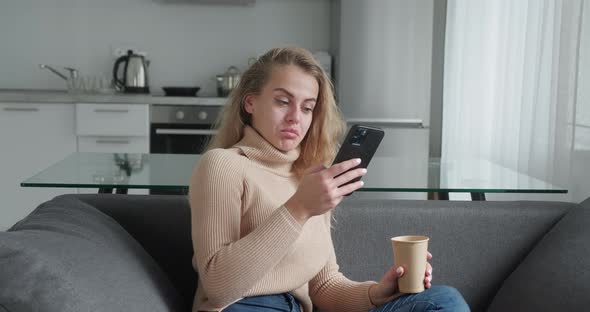 Young Blonde Woman at Home Smiling Girl Using App and Browsing on the Internet Typing Message on