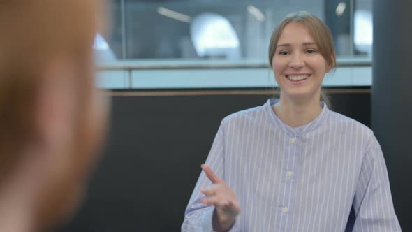 Rear View of Happy Young Woman Talking to Person