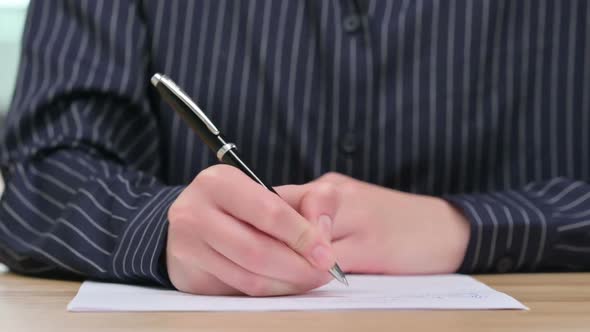 Close Up of Businesswoman Writing on Paper