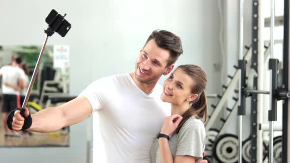 Young Athletic Couple Taking Selfie at Gym.