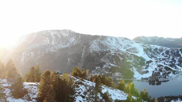 Drone Flight Over Two People Sitting On The Top Of Mountains