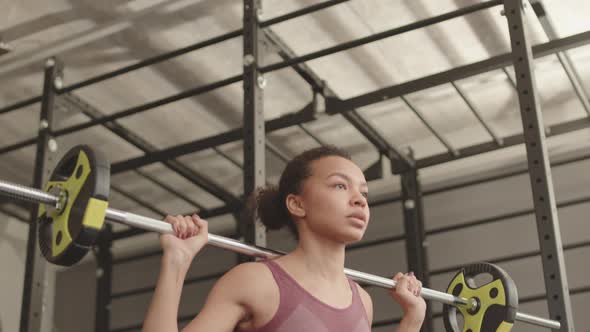 Mixed-Race Athlete Doing Squats with Barbell