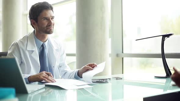 Doctor listening to patient in office