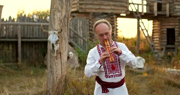 Folklore Traditions of the Slavic Peoples a Man in a Folk Costume Plays a Wooden Pipe