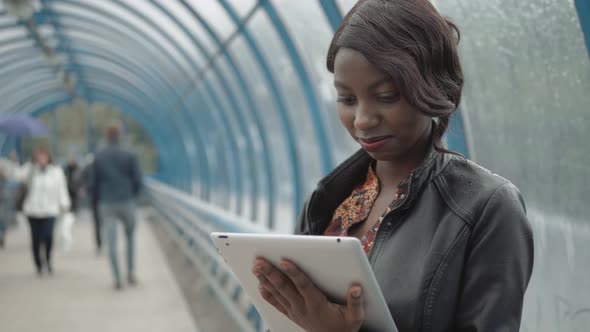 African American Girl, Student Working with Her Tablet in the Street, City Street, Subway, Happy