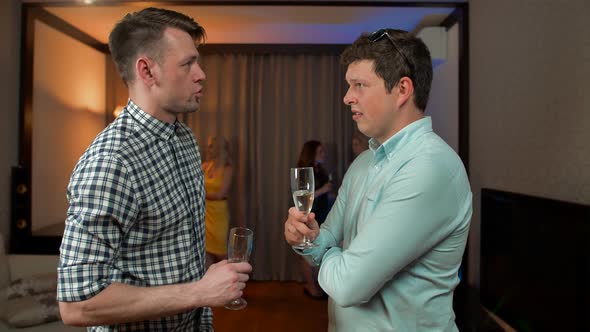 Two Male Friends Drinking Champagne in the Apartment