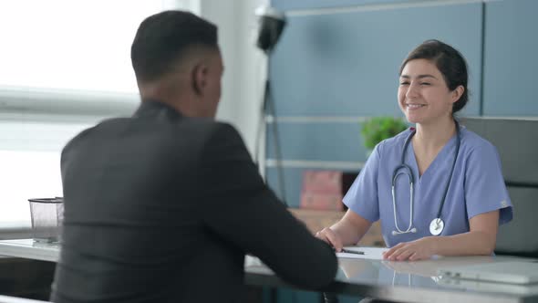 Indian Female Doctor Talking to African Man in Office