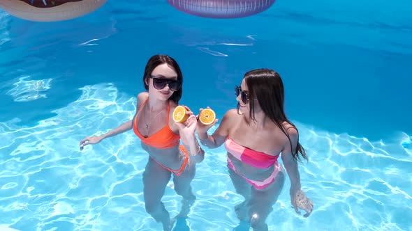 Two Girls Having Dancing and Having Fun in the Pool