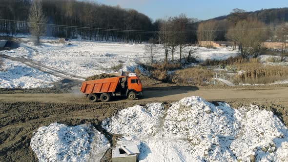 Truck moving around the Building filled with Earth