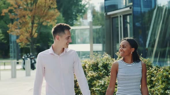 Mixedrace Family of Two Holding Hands Walking and Talking to Each Other