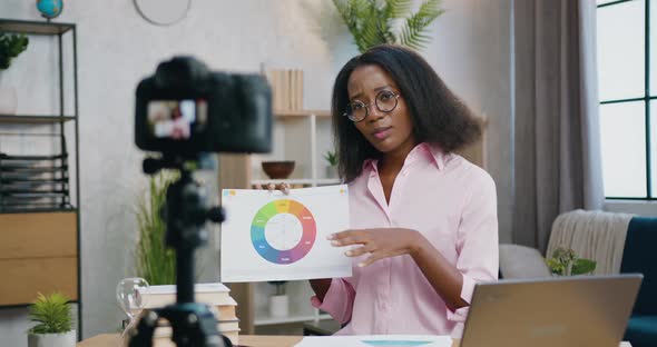 Female Coach in Glasses Explaining Diagram During Online Stream on Camera