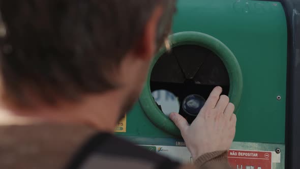 Young Man Male Hand Dropping Glass Plastic Bottle Into Recycle Bin and There are Waste Separation