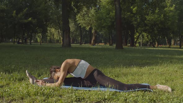 Flexible Female Doing Splits on Yoga Mat Outdoor