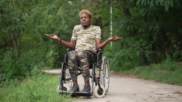 Brave African American Man in Wheelchair Meditating Sitting in Summer Park Outdoors with Closed Eyes
