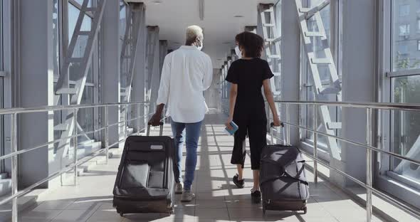 Back View of Afro American Couple Walking Together in Airport Going on Vacation Trip. Travel