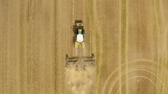  Tractor plows ground on cultivated farm field. 