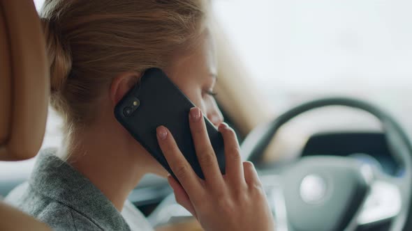 Back View of Woman Talking Phone at Car. Female Leaning on Steering Wheel at Car