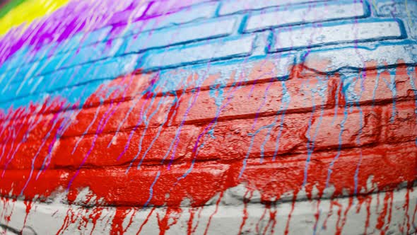 Colorful paint leaks on an old brick wall. Endless looping animation. 4KHD