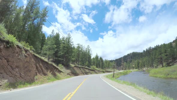 POV point of view -Driving on small road near the mountain creek in rural area of Western Colorado.