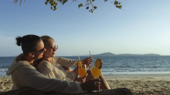 Loving Couple in White Dress Sunglasses in Hugging Relax and Drinking Cocktail