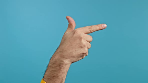 Hand of Man Doing Shot Showing Fire Gun or Weapon Gesture with Finger Isolated on Blue Studio