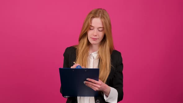 Close Up of a Businesswoman Write on a Paper Isolated on Pink Background
