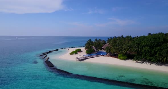 Wide angle drone tourism shot of a sandy white paradise beach and blue water background