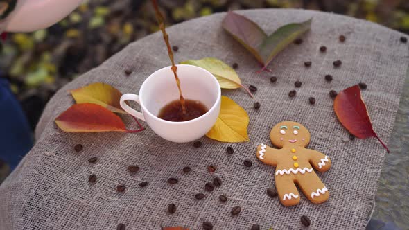 Gingerbread Man and Cup of Coffee Near Autumn Leaves