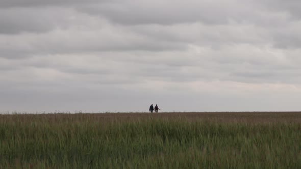 elderly couple walking in a field in the countryside with left to right pan