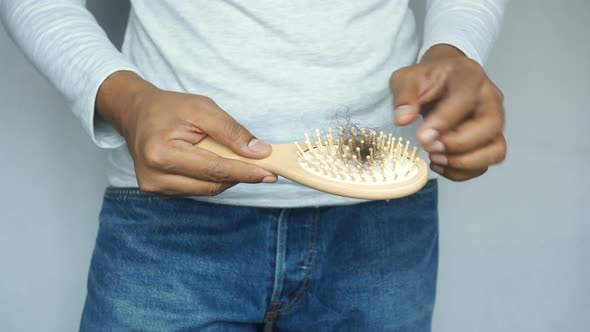 Men Hand Hold a Brush with Lost Hair